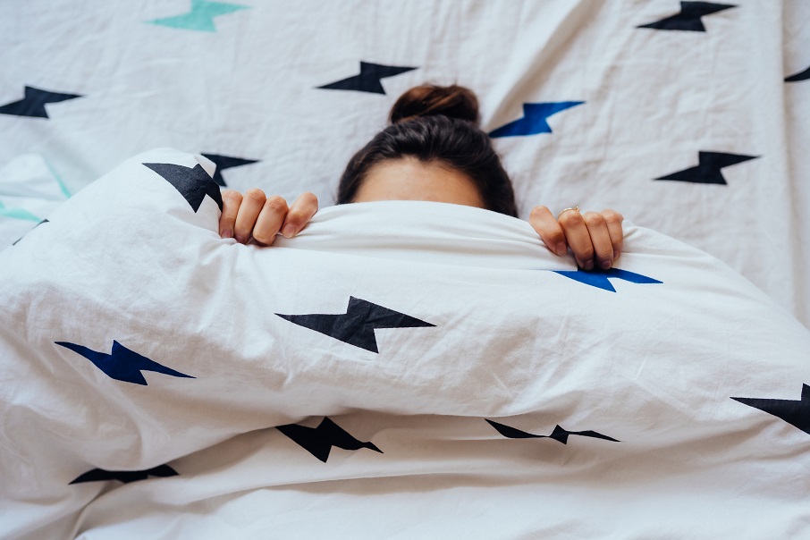 closeup-lovely-young-woman-lies-bed-covered-with-blanket