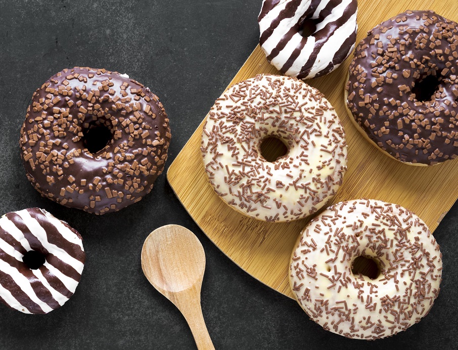 top-view-donuts-chopping-board-with-wooden-spoon