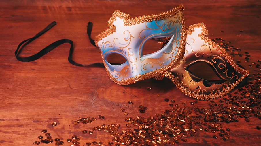 two-blue-golden-carnival-mask-with-glittering-sequins-wooden-desk